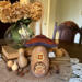 A mushroom house made from natural gourds. The original gourd stem on the top. A "Squirl Cottage" house sign hangs on the side. 